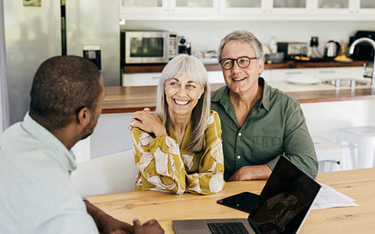 A licensed advisor going over coverage with a couple at their kitchen table
